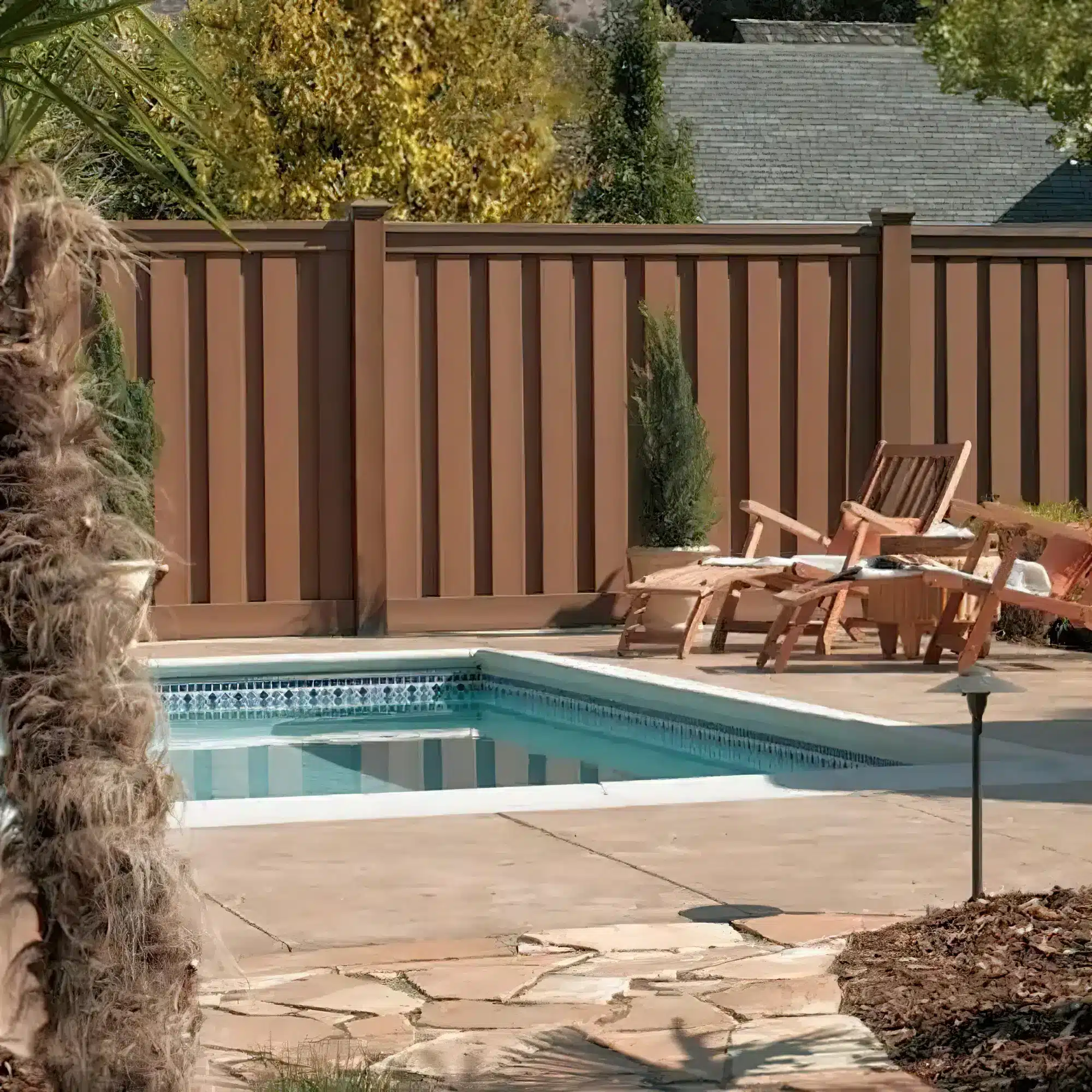 Residential swimming pool enclosed by a finished privacy fence